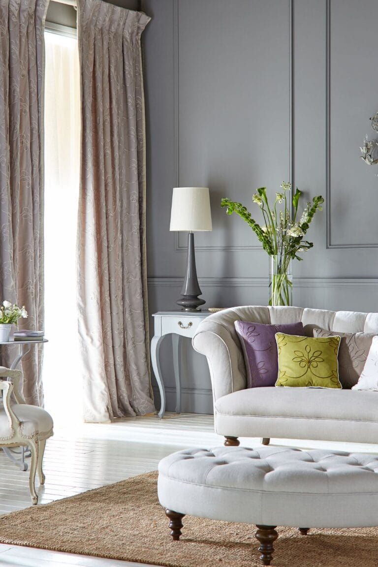 cool gray living room with tufted furniture warm accent pillows and natural light