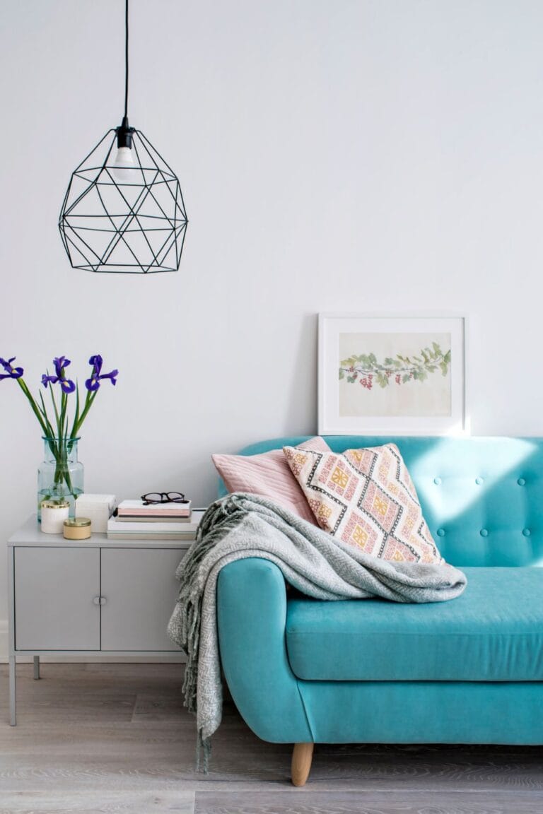 modern living room with blue sofa patterned pillows and geometric pendant light